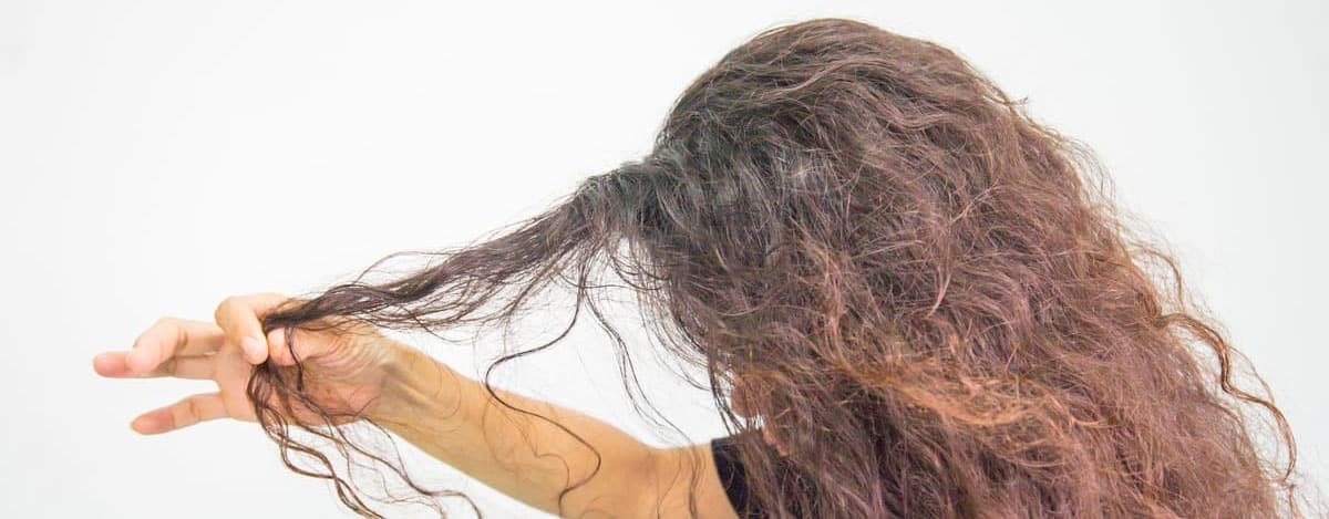 Mulher a puxar os seus cabelos encaracolados