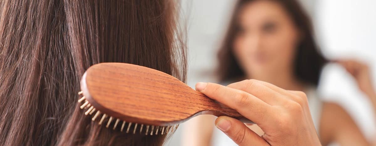 Imagem de uma menina a escovar o cabelo.