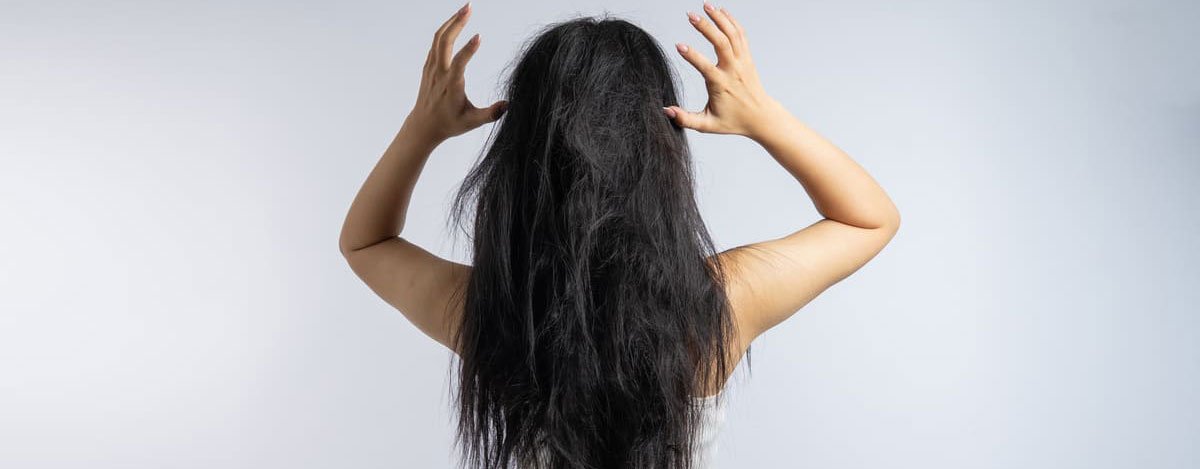 Imagem de uma mulher de costas, com o cabelo despenteado.