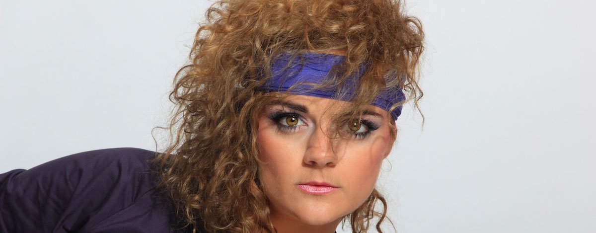 Imagem de uma mulher com um penteado típico dos anos oitenta.