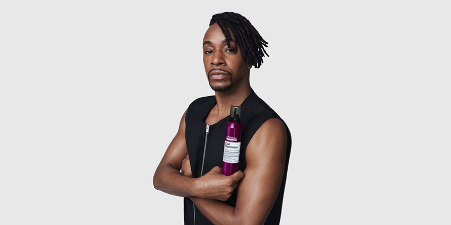 O foco está num homem com cabelo encaracolado estilizado a segurar o Sérum Curl Expression, ilustrando a rotina de cuidados capilares L’Oréal Men para todos os tipos de caracóis.