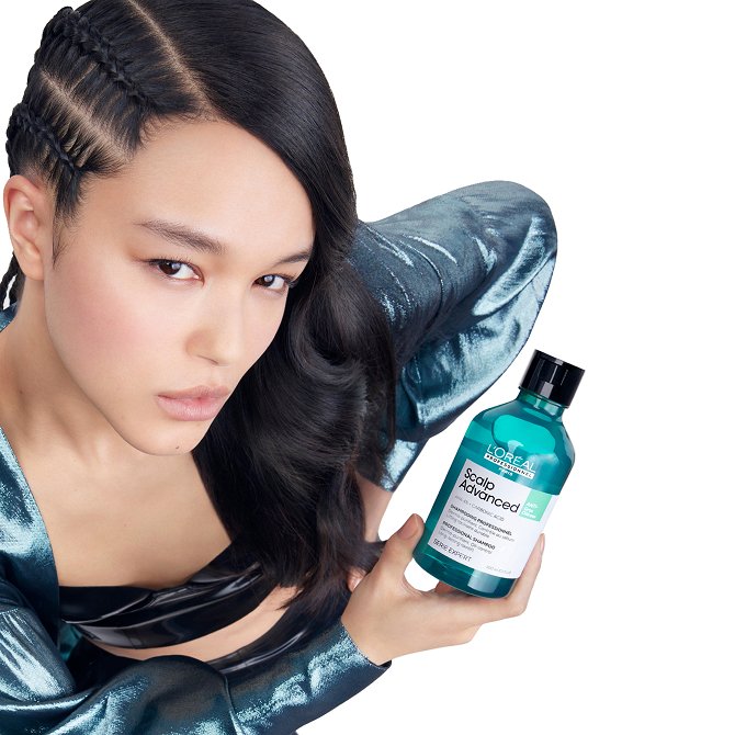 Mulher a segurar um frasco do champô L’Oréal Scalp Advanced, apresentando a linha desenvolvida para eliminar a oleosidade do cabelo.