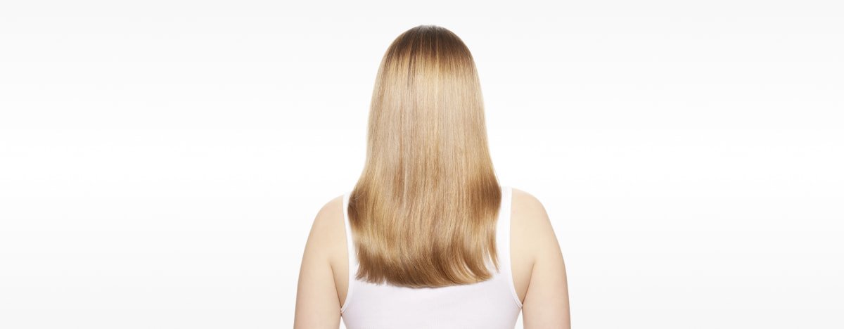 Mulher com o cabelo visivelmente reparado, apresentando maior força, suavidade e brilho após seguir o guia definitivo para reparar o cabelo danificado.