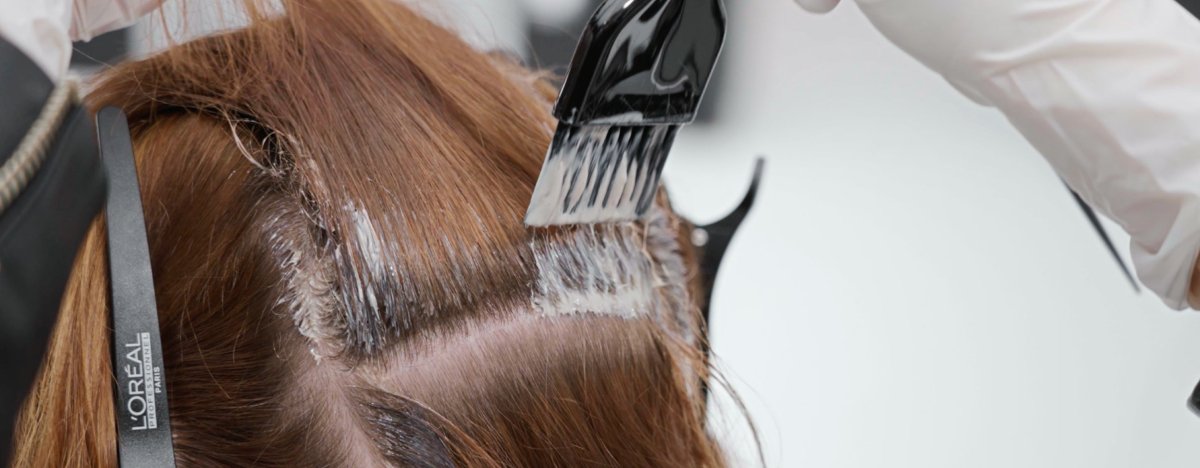 O foco está numa mulher no salão de cabeleireiro que tem os seus cabelos pintados profissionalmente com a moderna cor Castanho Espresso.