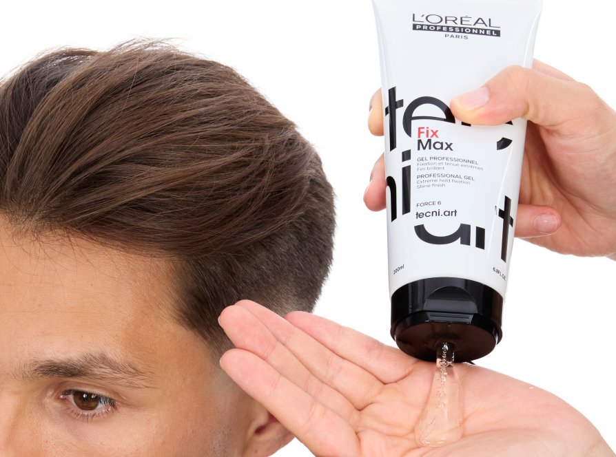 O foco está no cabelo de um homem a ser estilizado por um cabeleireiro profissional usando gel de styling, seguindo a última tendência de penteados.