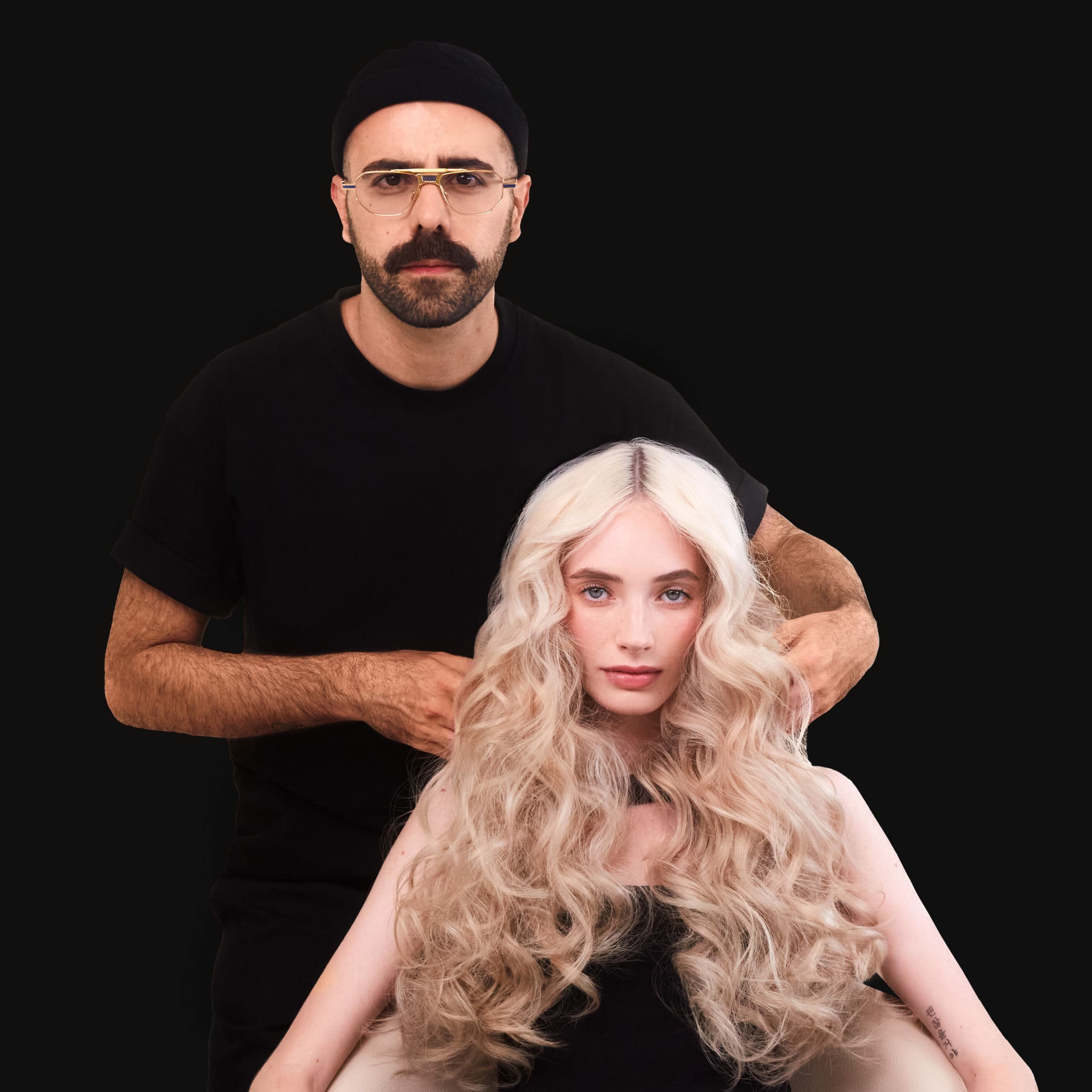 Imagem de Claudio Bertille com uma cliente de cabelo loiro e ondulado.